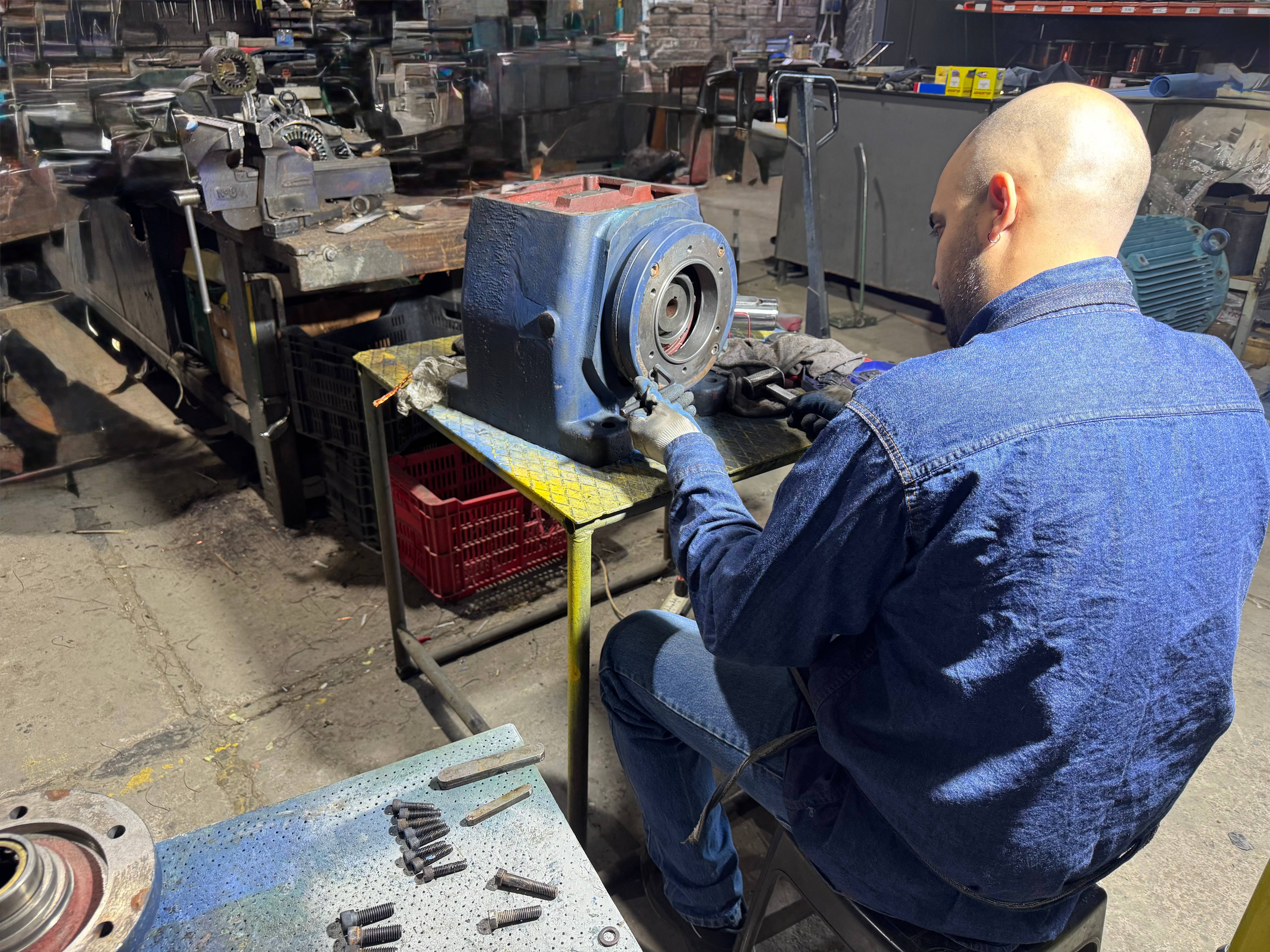 Técnico BEMEC reparando reductor de velocidad en taller especializado